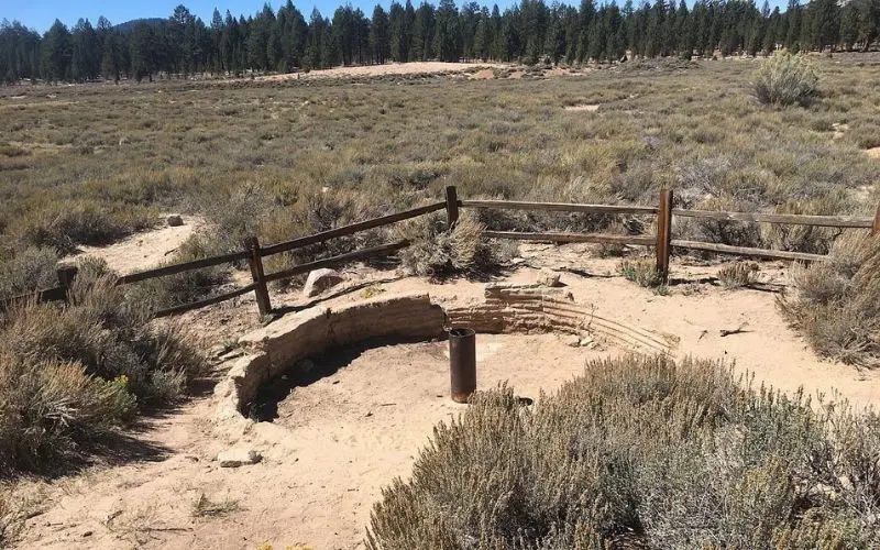 An old stone fire pit remains in the open fields of Holcomb Valley.