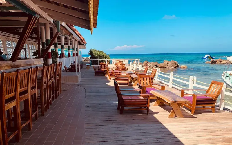 Outdoor seating area by the sea at Franklyn D. Resort in Jamaica.