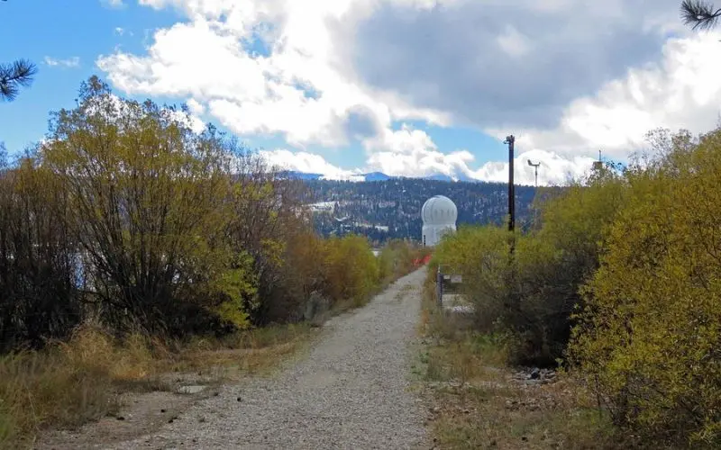 The white dome of the Big Bear Solar Observatory is seen along a mountain path.