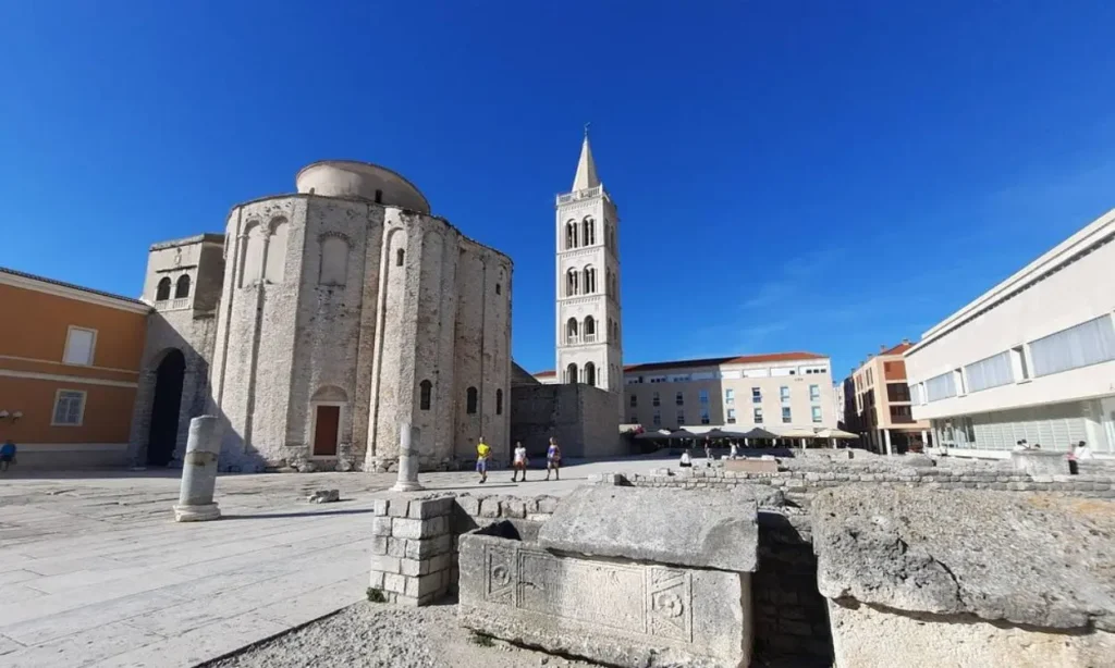 St. Donatus Church stands with its round stone structure and tall bell tower.