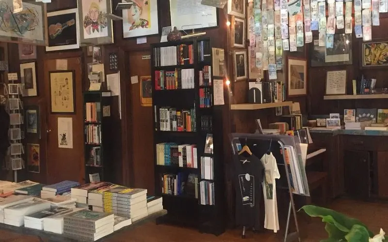 Interior of Henry Miller Library with books, art, and hanging decorations.