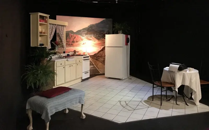 Small stage set with a kitchen and dining area at Pacific Resident Theatre.