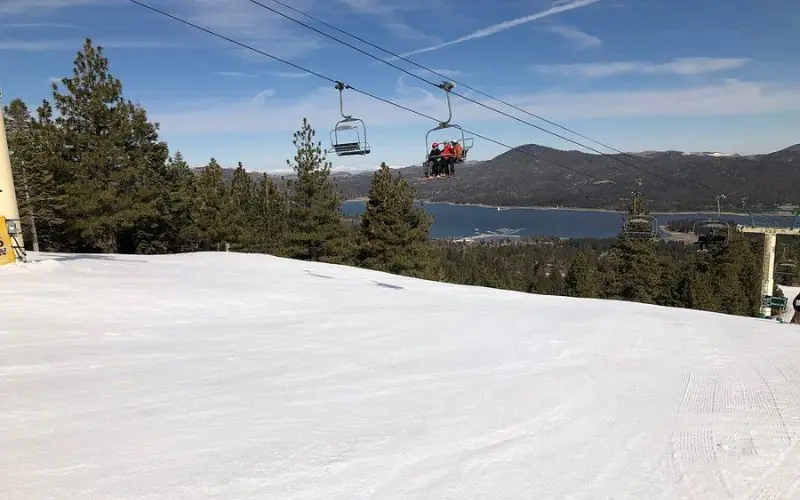 Skiers ride the chairlift above snowy slopes at Snow Summit.