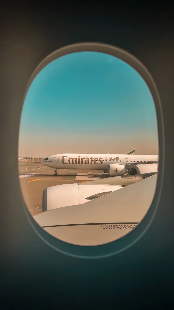 Emirates Boeing 777 parked on the tarmac viewed through an airplane window
