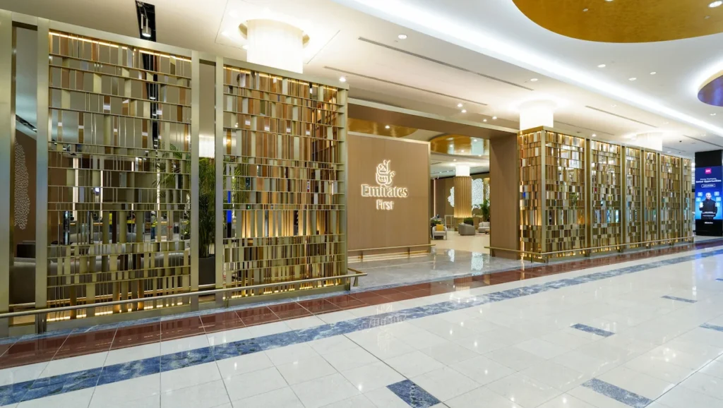 Emirates First Class Lounge entrance with an illuminated logo and gold geometric screens
