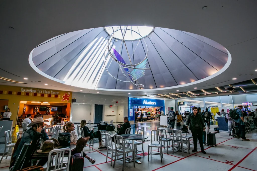 Harry Reid Airport seating area under a circular dome skylight with a hanging metal sculpture