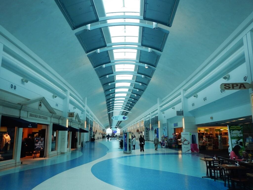 A long hallway inside Jacksonville International Airport lined with shops and spas