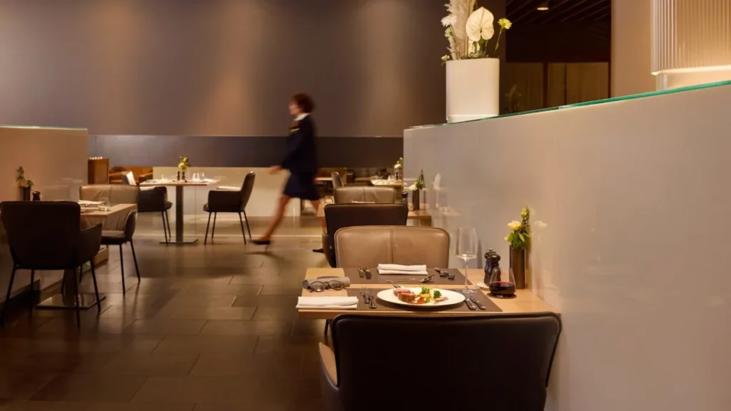 Lufthansa First Class Terminal dining area with leather armchairs and set dinner tables