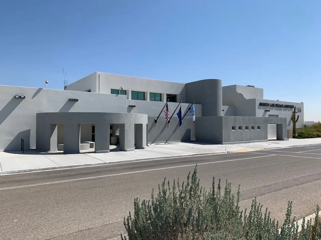 Exterior of the grey North Las Vegas Airport terminal building under a clear blue sky