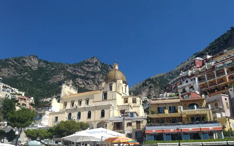 Dome of the Church of Santa Maria Assunta in Positano with hillside houses.