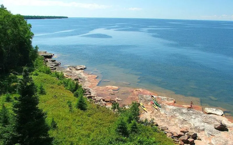 A rocky shoreline with kayaks along the water at Apostle Islands National Lakeshore.