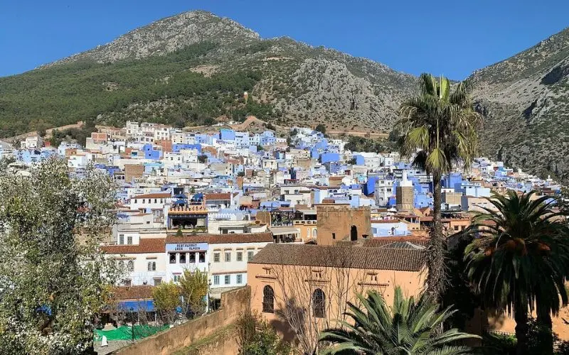 View of Chefchaouen with blue-painted houses at the foot of the Rif Mountains.