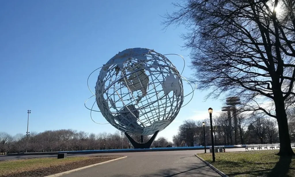 The Unisphere sculpture stands tall under a clear blue sky at Flushing Meadows Corona Park.