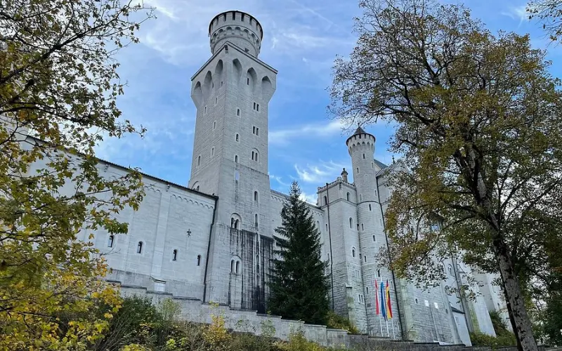 View of Neuschwanstein Castle's tall white towers surrounded by trees.