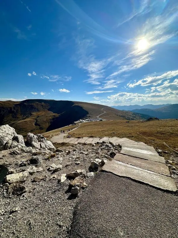 Winding mountain road under a bright sky on Trail Ridge Road.