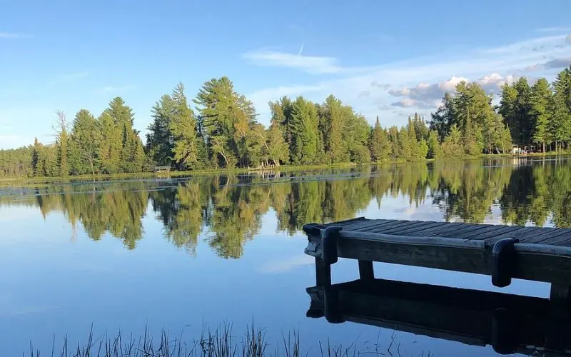 A wooden dock extends into the calm waters of Eagle River Chain of Lakes.