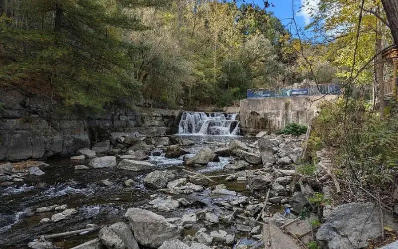 A peaceful scene along the Keuka Outlet Trail with waterfalls and rocks.