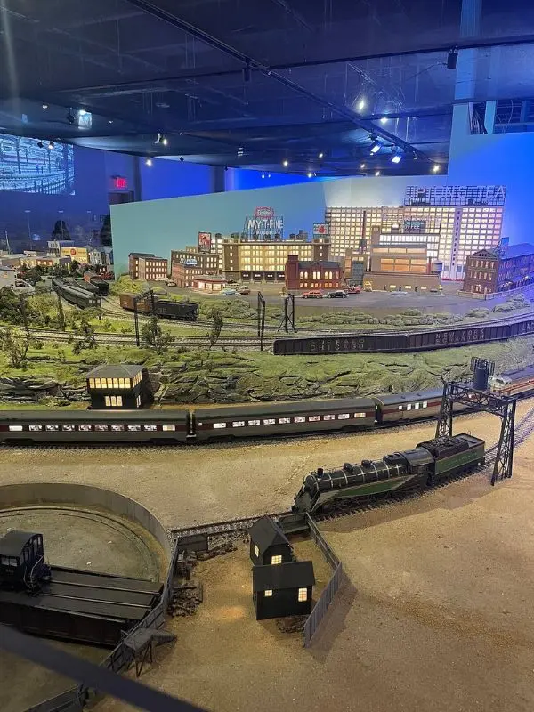 A detailed model train exhibit inside Liberty Science Center with buildings and tracks.