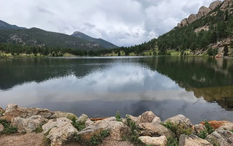 Calm reflective water with forested hills at Lily Lake.