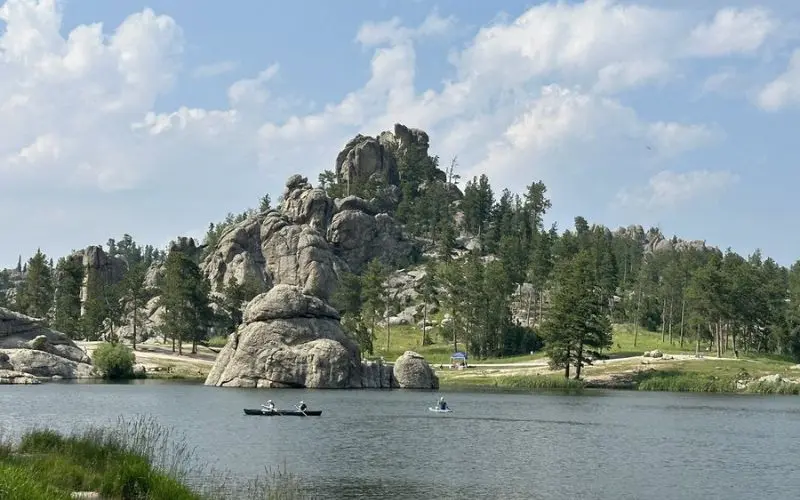 Canoes and kayaks float on the calm waters of Sylvan Lake.