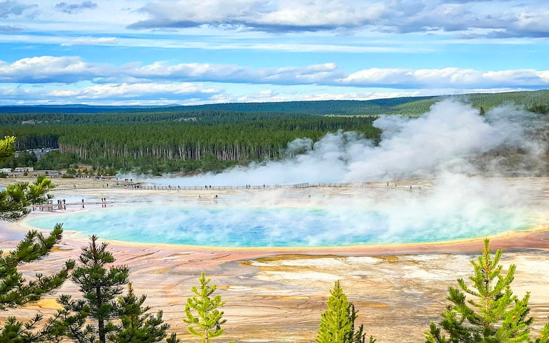 The Grand Prismatic Spring is a vivid beauty for its stunning rainbow hues above crystal waters that draw global crowds. 