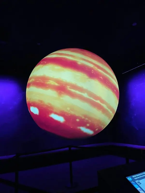 A glowing planet display is showcased in a dark room at the Adirondack Public Observatory.