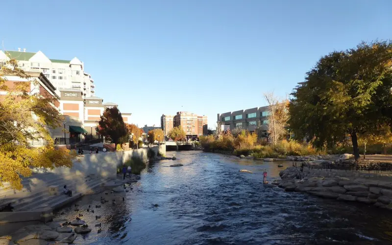 Reno has a city riverwalk with trees, buildings, and flowing water.