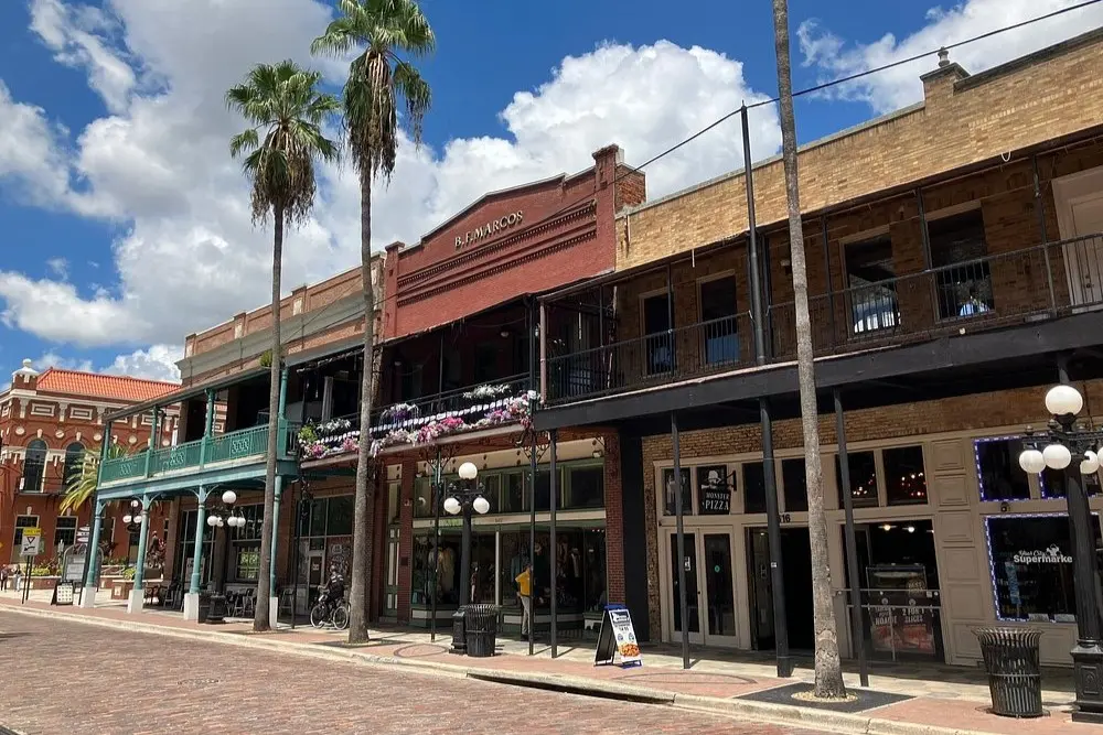 Historic brick buildings and palm trees along a street in Ybor City, Tampa.