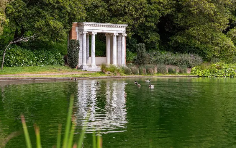 Golden Gate Park has a small white Greek-style structure by a pond.