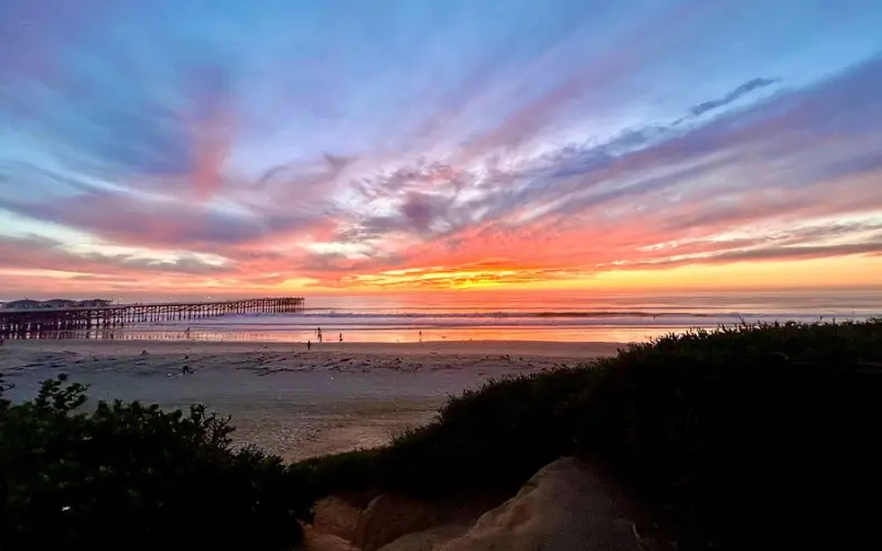 A colorful sunset reflects over the ocean at Pacific Beach.