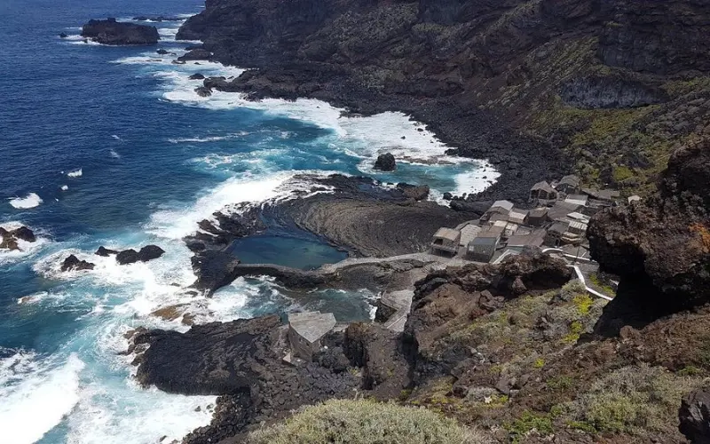 Rocky shoreline and tidal pools with small houses on El Hierro.