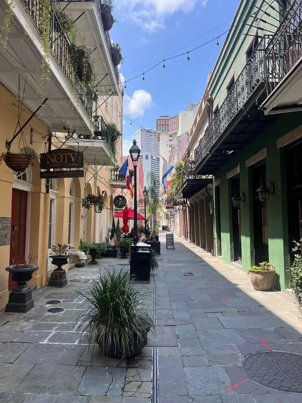 Colorful buildings and flags line a narrow street in the French Quarter.