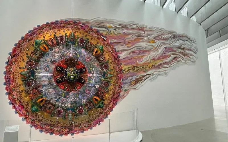 A colorful circular glass artwork is displayed at the Corning Museum of Glass.