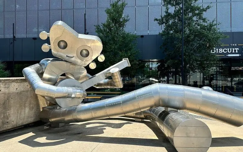 A silver robot statue plays banjo in Deep Ellum.