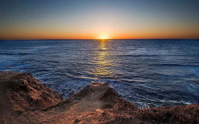 The sun sets over the ocean cliffs at Sunset Cliffs Natural Park.