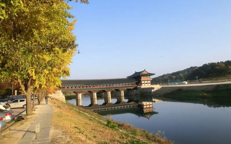 A wooden covered bridge over a river in Gyeongju.