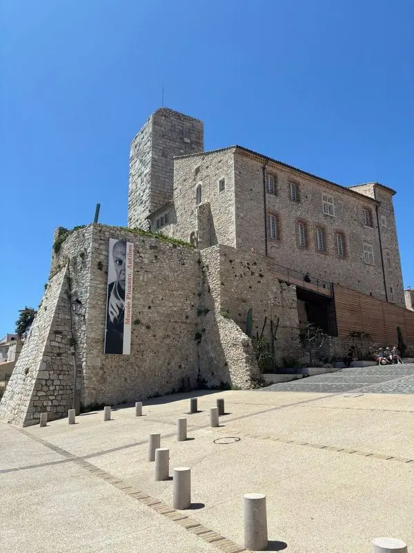 The stone exterior of the Picasso Museum rises against a clear blue sky.