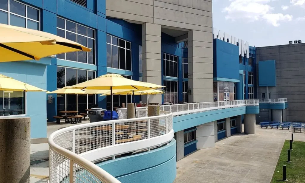 The exterior of The Adventure Aquarium with blue walls and yellow umbrellas on the patio.