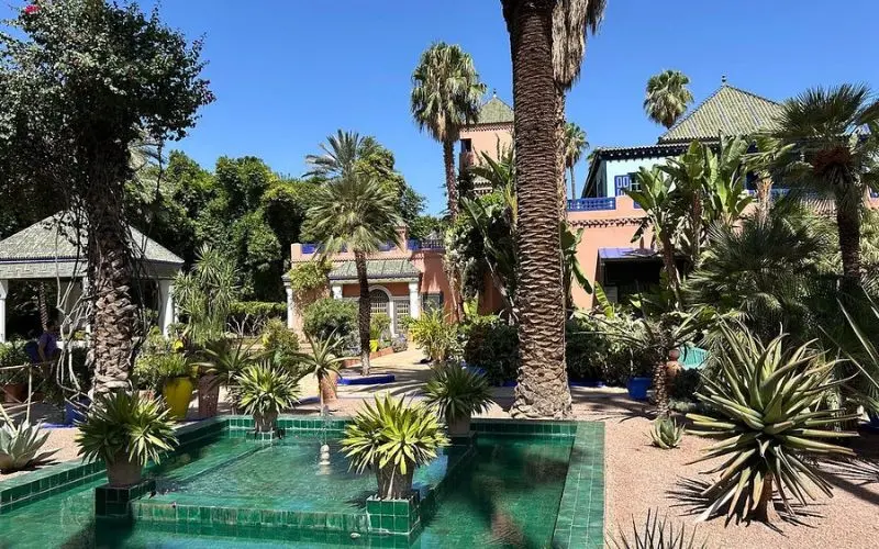 Palm trees and tiled fountain inside the Majorelle Garden in Marrakech.