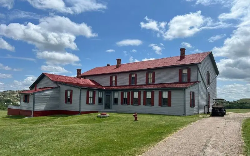 Historic red-roofed house on green grass at Chateau de Mores.