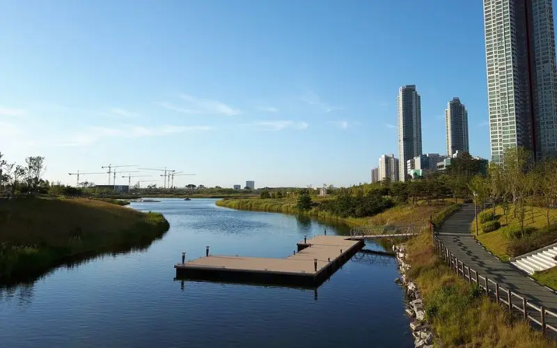 A riverside park with tall buildings in Incheon.