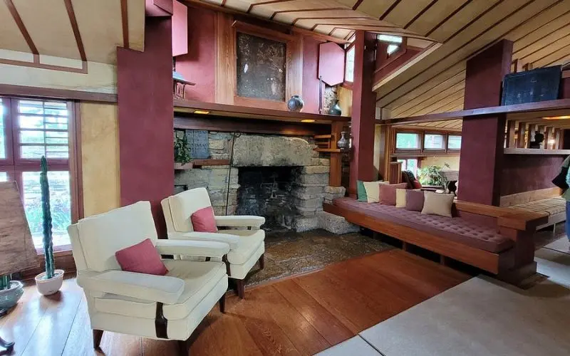 A cozy interior with stone fireplace inside Frank Lloyd Wright’s Taliesin.