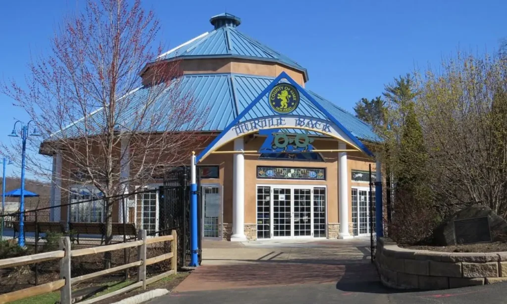 The entrance to Turtle Back Zoo with a blue roof and a triangular sign.