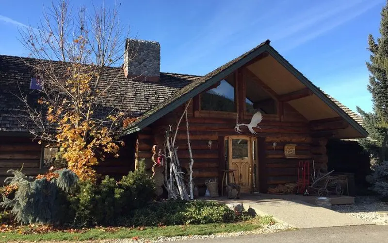 Rustic log building surrounded by trees at Icicle Ridge Winery.