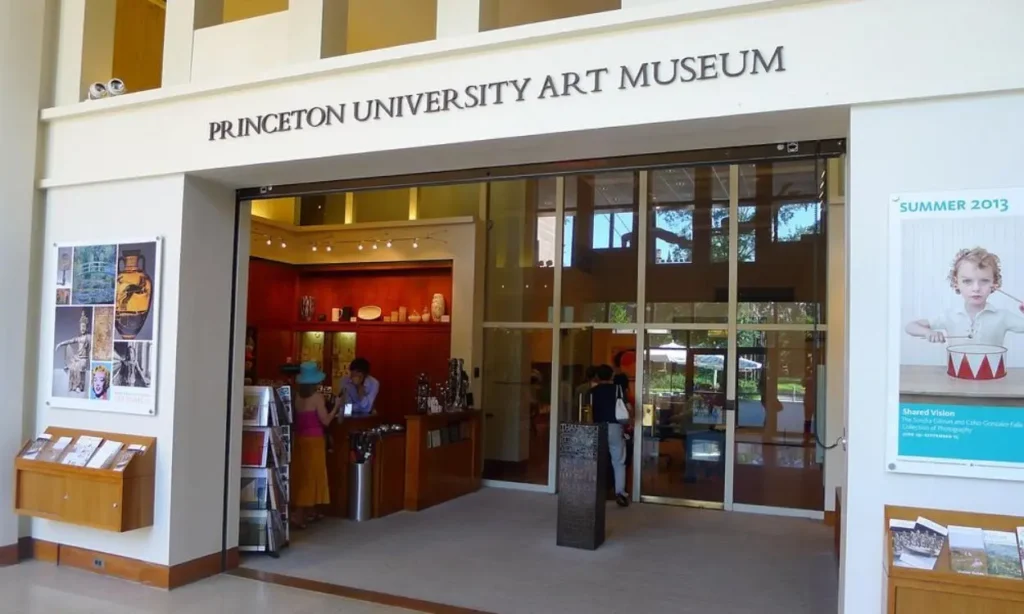 The front entrance of the Princeton University Art Museum with visitors inside the lobby.