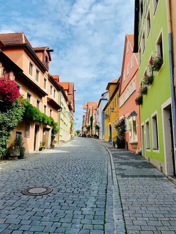 Colorful buildings line a cobblestone street on the Romantic Road.
