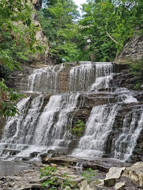 A multi-tiered waterfall cascades down rocks at Cascadilla Gorge.