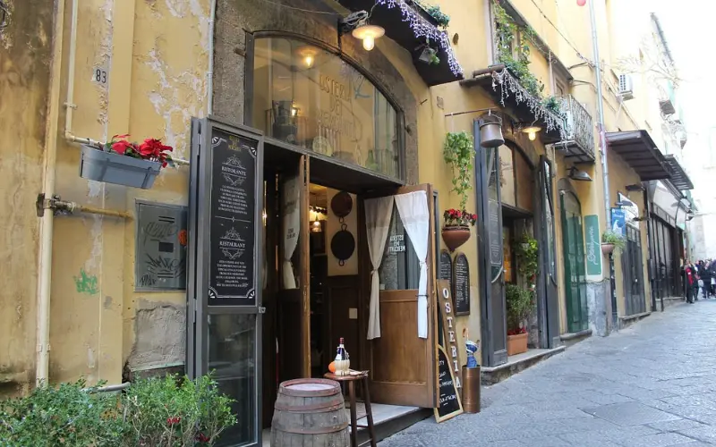 Narrow street with restaurants and shops in Salerno.
