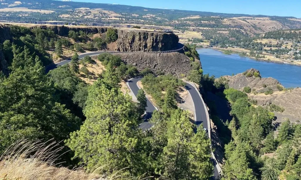 Winding road along cliffs with views of the river at Columbia River Gorge.