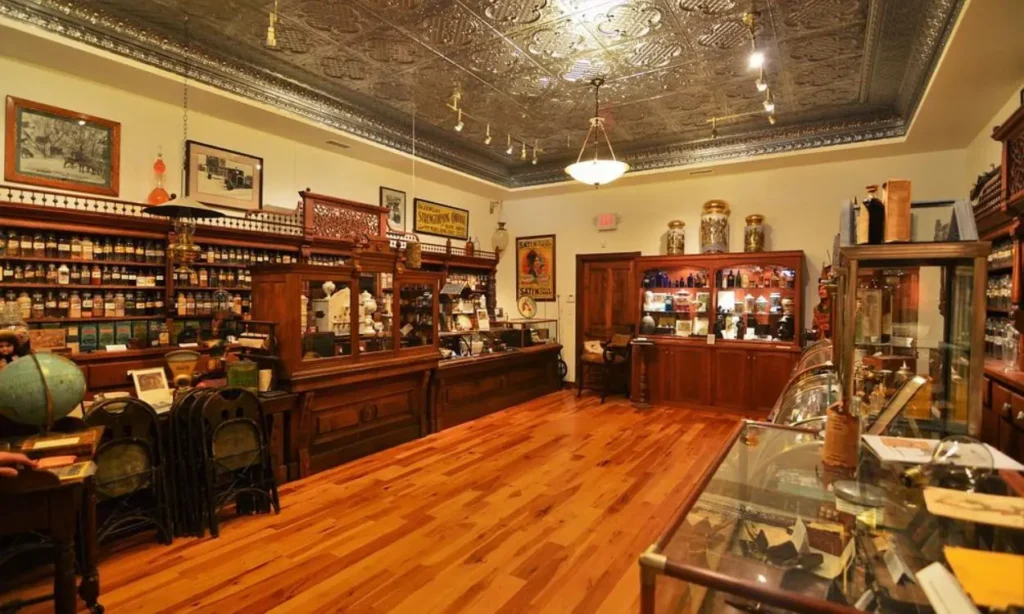 The vintage interior of the Ouray Alchemist Museum with wooden shelves and antique jars.
